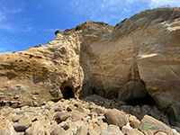 Boulder covered beach platform withsea caves near small faults.